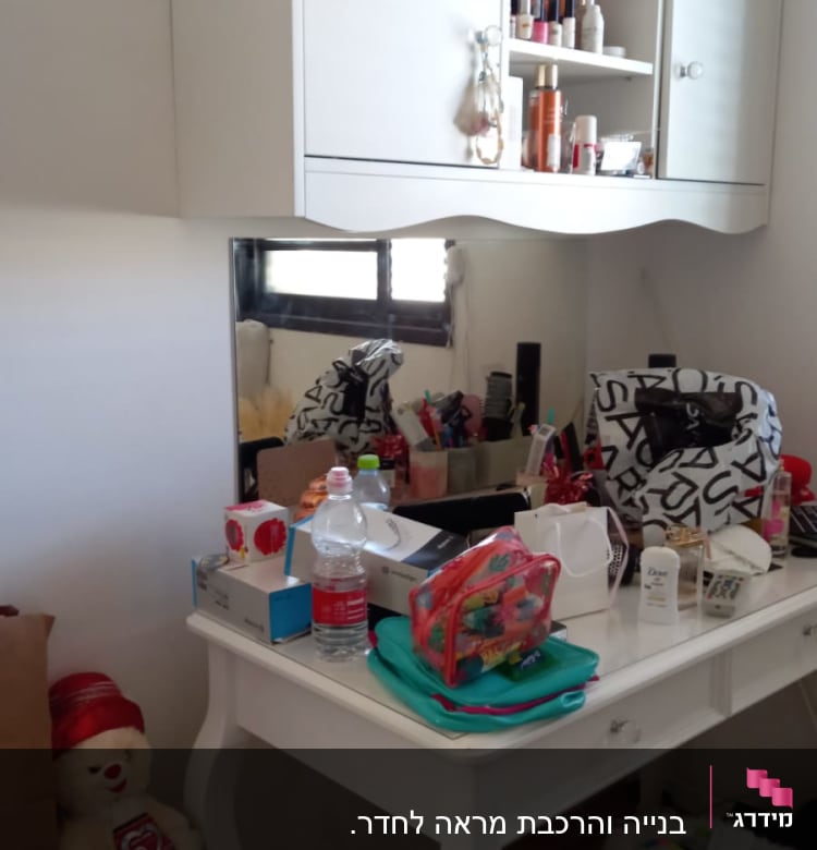 מראה מלבנית על קיר מעל שולחן לבן